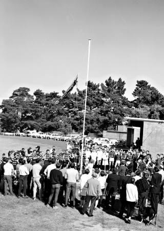Parkdale Football Club members and players gather round to fly the pennant won by the club's seconds [picture].