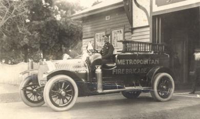 Fireman Brown at the wheel of a fire engine, c1920 [picture].