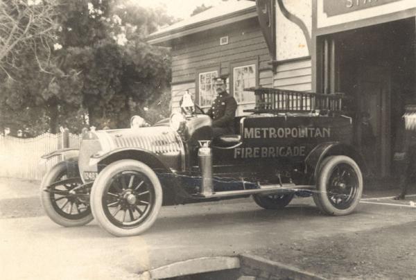 Fireman Brown at the wheel of a fire engine, c1920 [picture].