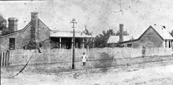 Two small timber cottages in Skinner Street Hastings with a young girl standing next to the street lamp [picture].